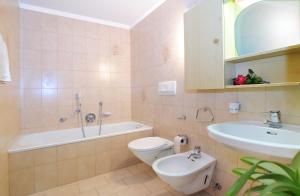 a bathroom with a sink and a toilet and a bath tub at Gasthof Anich in Natz-Schabs +20 photos
