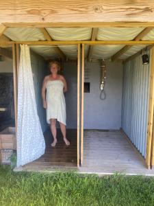 a woman standing inside of a covered porch at Raaum Gard, hytte 3 in Luster +1 photo