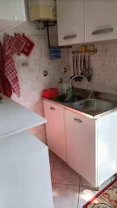 a kitchen with white cabinets and a sink at Casa Nonno Maiti in Scardovari +10 photos