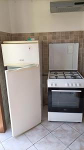 a kitchen with a white stove and a refrigerator at Casa Nonno Maiti in Scardovari