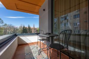a balcony with two chairs and a table on the roof at Habitat Suites II in Craiova
