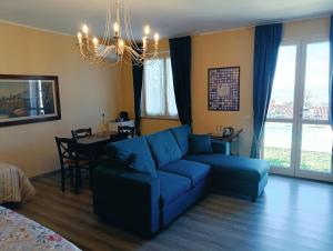 a living room with a blue couch and a table at Domus Langhe B&B in Treiso