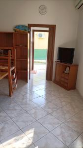 a living room with a television and a tiled floor at Casa Nonno Maiti in Scardovari
