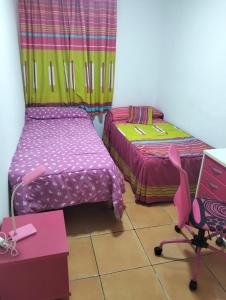 a room with two beds and a desk and a chair at Los Lentiscares Apartment in Torrox Costa