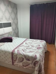 a bed in a bedroom with a purple curtain at Los Lentiscares Apartment in Torrox Costa +36 photos