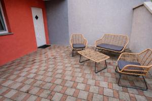 three chairs and a table in front of a building at Apartment Seka in Podčetrtek