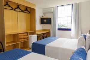 a hotel room with two beds and a television at Pousada do Garimpo in Diamantina +53 photos