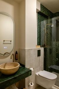 a bathroom with a sink and a toilet and a mirror at Habitat Suites II in Craiova +33 photos