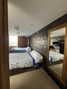 a bedroom with two beds and a mirror at Casa del Inka Perú in Lima