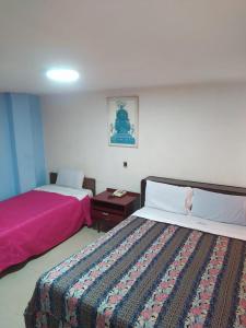 a hotel room with two beds and a pink blanket at Hotel Cristals Centro Bogota Estacion las Nieves Calle 18 numero 10 65 in Estación El Salto +5 photos