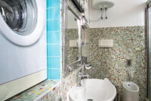 a bathroom with a sink and a washing machine at Authentic Lake Como Home near Bellagio in Limonta +42 photos