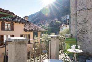 a table and chair on a balcony with a view of a mountain at Authentic Lake Como Home near Bellagio in Limonta