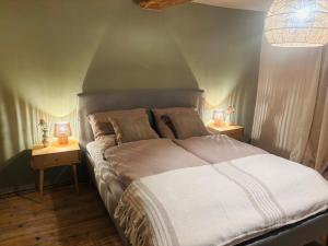 a bedroom with a large bed with two night stands at Gude Zeit Ferienhaus in Mörsdorf
