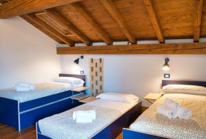 three beds in a room with wooden ceilings at Authentic Lake Como Home near Bellagio in Limonta