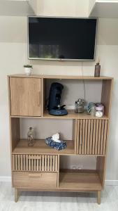 a wooden entertainment center with a flat screen tv on top at Chambre spacieuse et moderne in Sallertaine