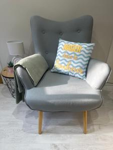 a gray chair with a pillow that reads mirror always be brother at Chambre spacieuse et moderne in Sallertaine