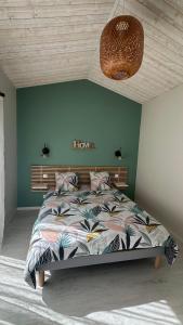 a bedroom with a bed with a green wall at Chambre spacieuse et moderne in Sallertaine