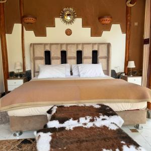 a bedroom with a large bed with a fur rug at Stardome Spiritual Experience in Ollantaytambo
