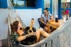 a man and a woman sitting in a hammock at Casa Omero Seaview. in El Cuyo
