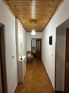 a hallway with white walls and a wooden ceiling at Sweet home Leskovik in Leskovik +4 photos