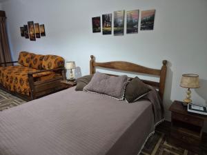 a bedroom with a bed and a chair at Colorina Bariloche en edificio Bariloche Center in San Carlos de Bariloche
