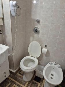 a bathroom with a toilet and a sink and a phone at Colorina Bariloche en edificio Bariloche Center in San Carlos de Bariloche
