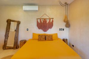 a bedroom with a yellow bed in a room at Casa Omero Seaview. in El Cuyo