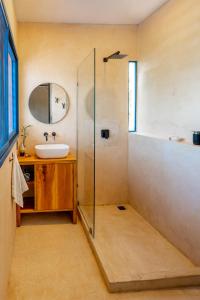 a bathroom with a sink and a glass shower at Casa Omero Seaview. in El Cuyo +15 photos