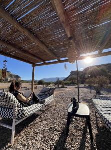 two people sitting on hammocks under a wooden umbrella at El Chiflon Posta Pueblo in El Chiflón