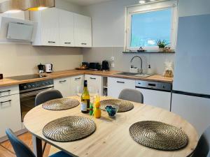 a kitchen with a wooden table with chairs and a dining room at Oaza Jeziorak in Siemiany