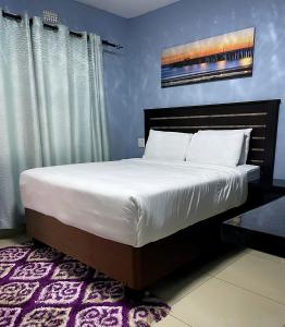 a bedroom with a large bed with white sheets at Bluenova guesthouse in Dundee