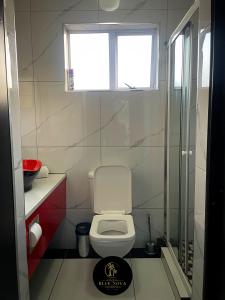 a small bathroom with a toilet and a window at Bluenova guesthouse in Dundee +14 photos