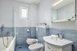 a white bathroom with a toilet and a sink at Libera Vista by MN Property in Kotor +22 photos