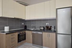 a kitchen with a stainless steel refrigerator and wooden cabinets at Libera Vista by MN Property in Kotor