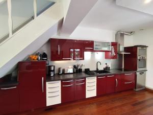 a kitchen with red cabinets and a staircase at La Ronce maison d hote - piscine SPA in Rouvres