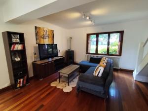 a living room with a couch and a tv at La Ronce maison d hote - piscine SPA in Rouvres