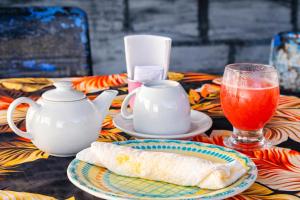a table with a plate of food and a drink at Pousada Vila Formosa in Belém +14 photos