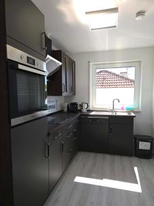a kitchen with black cabinets and a sink and a window at Ferienwohnung Groß-Umstadt in Groß-Umstadt