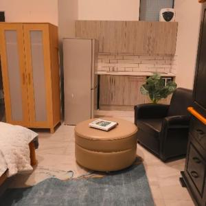 a living room with a couch and a chair and a refrigerator at eagle hights in Tierpoort