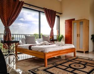 a bedroom with a bed in front of a large window at eagle hights in Tierpoort