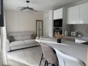 a kitchen and living room with a table and a couch at Le Refuge Douillet à 10min de Disneyland avec Parking Privé et Belle terrasse vue sur Jardin in Coupvray +24 photos