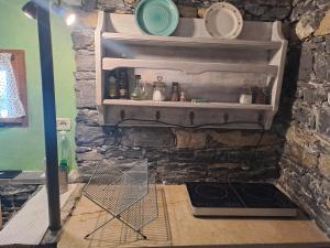 a kitchen with a stone wall with a stove at La Casetta di Molly tra ulivi e roseto in Leivi +15 photos