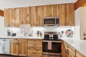 a kitchen with wooden cabinets and a stove top oven at Topnotch 329E in Stowe Fork
