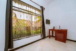 a room with a window with a table and a television at Farashuu Luna Hotel in Kendwa