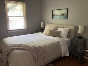 a bedroom with a large white bed with a window at Hidden Shores in Big Sandy