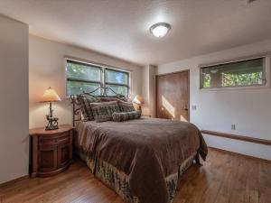 a bedroom with a large bed and two windows at Runnymeade Cottage in Kings Beach