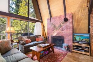 a living room with a brick fireplace and a tv at Runnymeade Cottage in Kings Beach