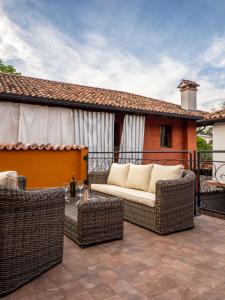 a patio with a couch and chairs on a balcony at Cjase san Pieri in Cividale del Friuli