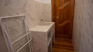 a bathroom with a white sink and a wooden door at Depa Urubamba in Urubamba