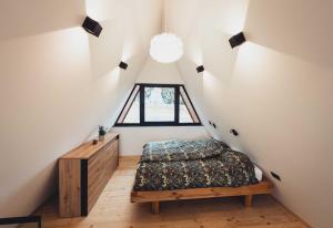 a attic bedroom with a bed and a window at Villa Perush in Vuzenica